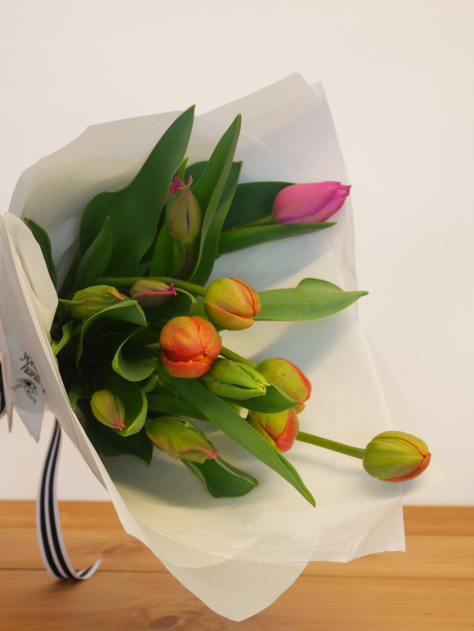 A bunch of fresh seasonal tulips in pinks, orange and green wrapped for pick up or delivery from Petone