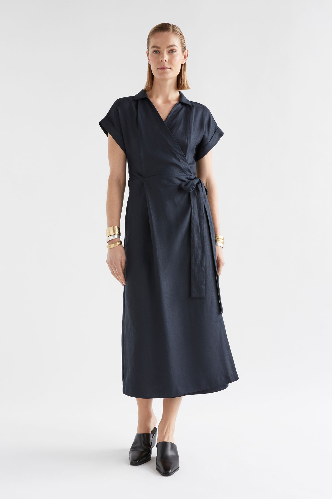 Woman wearing navy linen wrap dress.